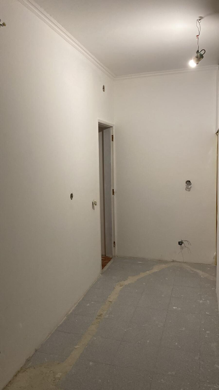 Corredor estucado em remodelação com caixas elétricas embutidas e pontos de luz preparados antes dos acabamentos